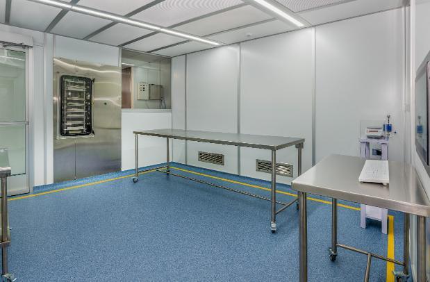 A silver table inside a cleanroom with a blue floor